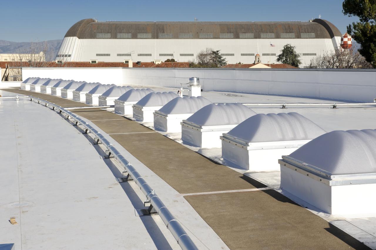 Construction of the new NASA Ames Green Building dubbed Sustainability Base located on the Ames Research Center campus at Moffett Field, CA. Skylight and piping on roof, Hangar One in background.