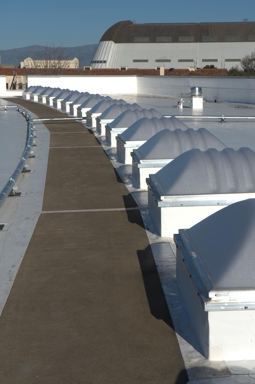 Construction of the new NASA Ames Green Building dubbed Sustainability Base located on the Ames Research Center campus at Moffett Field, CA. Skylight and piping on roof, Hangar One in background.