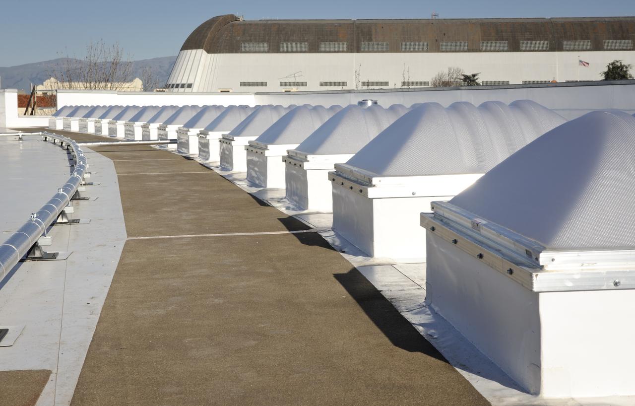 Construction of the new NASA Ames Green Building dubbed Sustainability Base located on the Ames Research Center campus at Moffett Field, CA. Skylight and piping on roof, Hangar One in background.