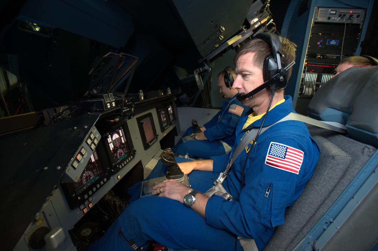STS-135 astronaut training in the Vertical Motion Simulator, Ames Research Center, Moffett Field, CA. Mission Chris Ferguson commander in forground, Doug Hurley, pilot in background are in VMS S-cab cockpit for simulated landing practice under a variety of landing sites and conditions.