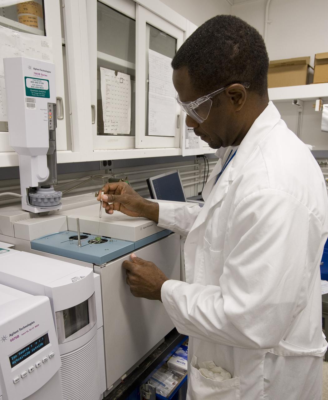 Dr George Cooper analyzes metoritic material by injecting samples into gas chromatograph-mass spectrometer. This instrument separates very complicated molecular mixtures into individual componds that are more easily identified.