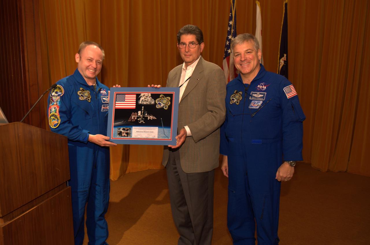 Pilot Greg Johnson and Mission Specialist Mike Fincke of Space Shuttle Endeavour's final mission STS-134 come to Ames Research Center to share their experiences, answer questions and sign autographs during a afternoon with the staff. Astronauts Johnson and Fincke present photo to Ames Associate Director Steve Zornetzer.