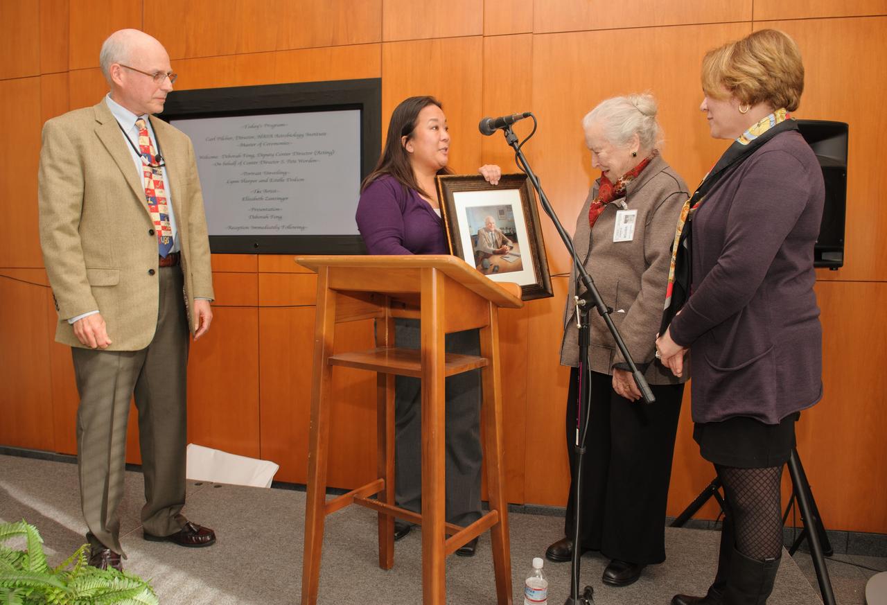 Dr. Brauch Blumberg portrait unveiling ceremony held at the Syverston Auditorium (N-201) NASA Ames Researc Center, Moffett Field, CA. From left, Carl Pilcher and Deb Feng present a copy of the painting to the Blumberg family.