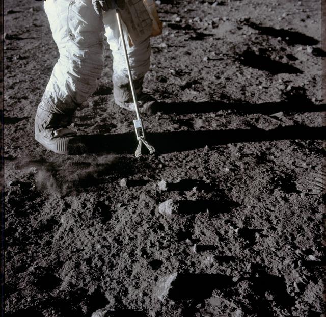 Close-up view of set of tongs being used to pick up lunar samples