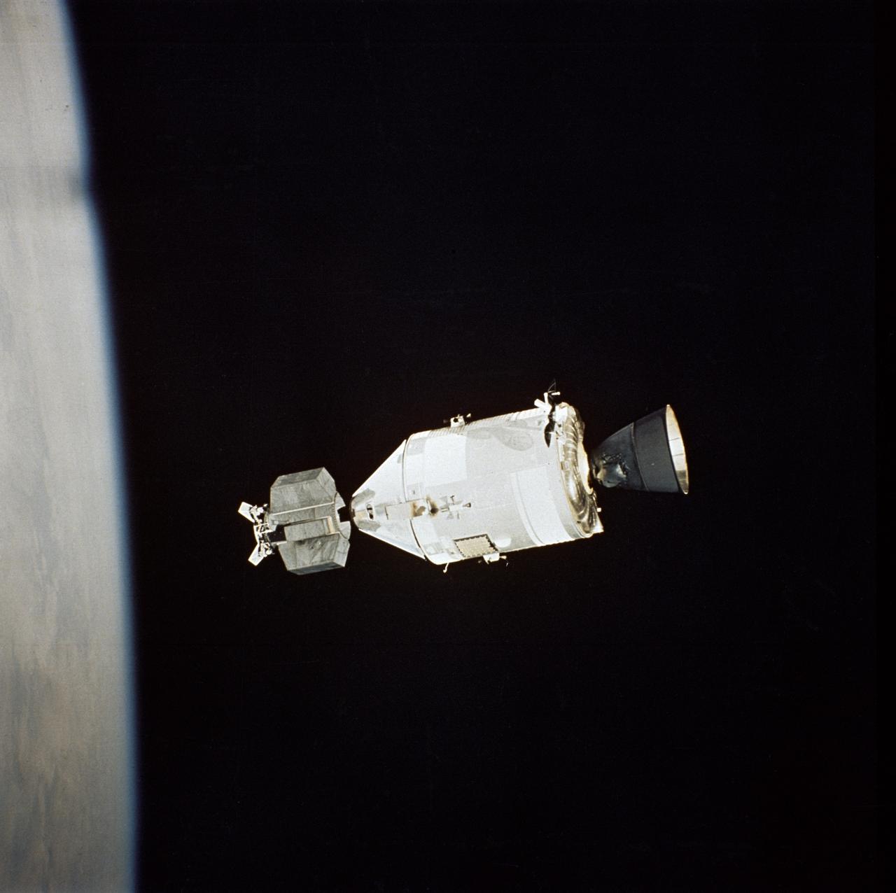 AST-32-2695 (17-19 July 1975) --- The American Apollo spacecraft as seen in Earth orbit from the Soviet Soyuz spacecraft during the joint U.S.-USSR Apollo-Soyuz Test Project mission. The Command/Service Module and Docking Module are contrasted against a black-sky background. The horizon of Earth is below. This picture was furnished by the USSR in an exchange of photography taken during the ASTP flight. The bell-shaped engine nozzle of the service propulsion system protrudes from the rear of the Service Module. Note the docking mechanism on the Docking Module. The American and Soviet spacecraft were joined together in space for approximately 47 hours on July 17-18-19, 1975. PHOTO COURTESY: USSR ACADEMY OF SCIENCES