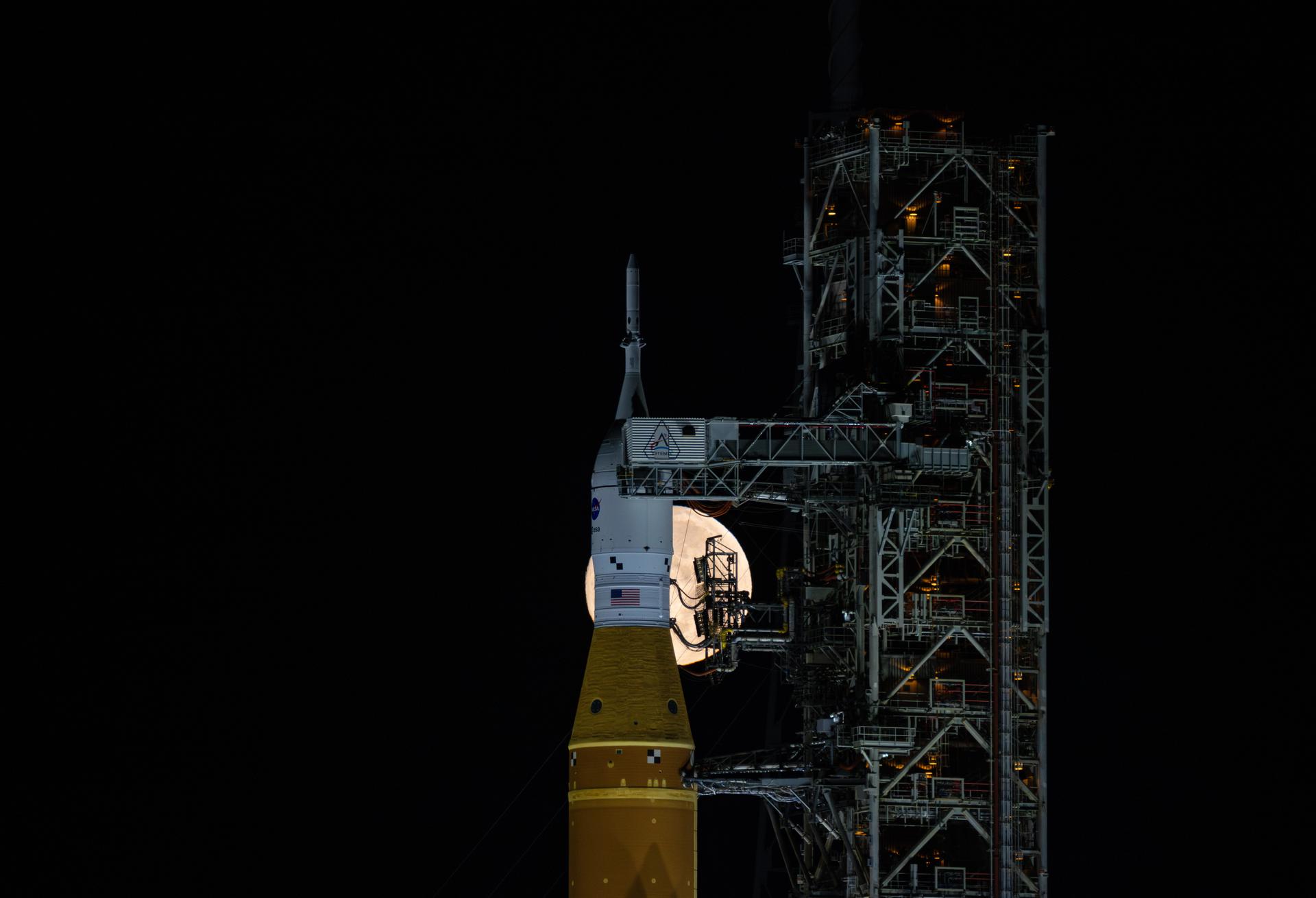 A full Moon is seen shining over NASA’s SLS (Space Launch System) and Orion spacecraft, atop the mobile launcher in the early hours of February 1, 2026. The rocket is currently at Launch Pad 39B at NASA’s Kennedy Space Center in Florida, as teams are preparing for a wet dress rehearsal to practice timelines and procedures for the launch of Artemis II.