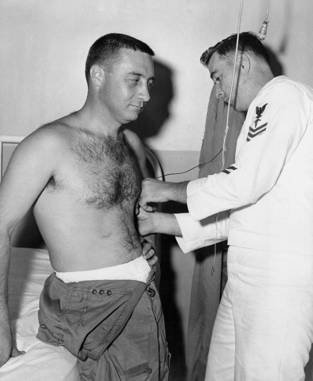 B59-00586 (1959) --- Astronaut Virgil (Gus) Grissom is seen preparing for training in the centrifuge at Johnsville. A Navy corpsman attaches sensors to Grissom to monitor his body's reaction to the centrifuge. Photo credit: NASA