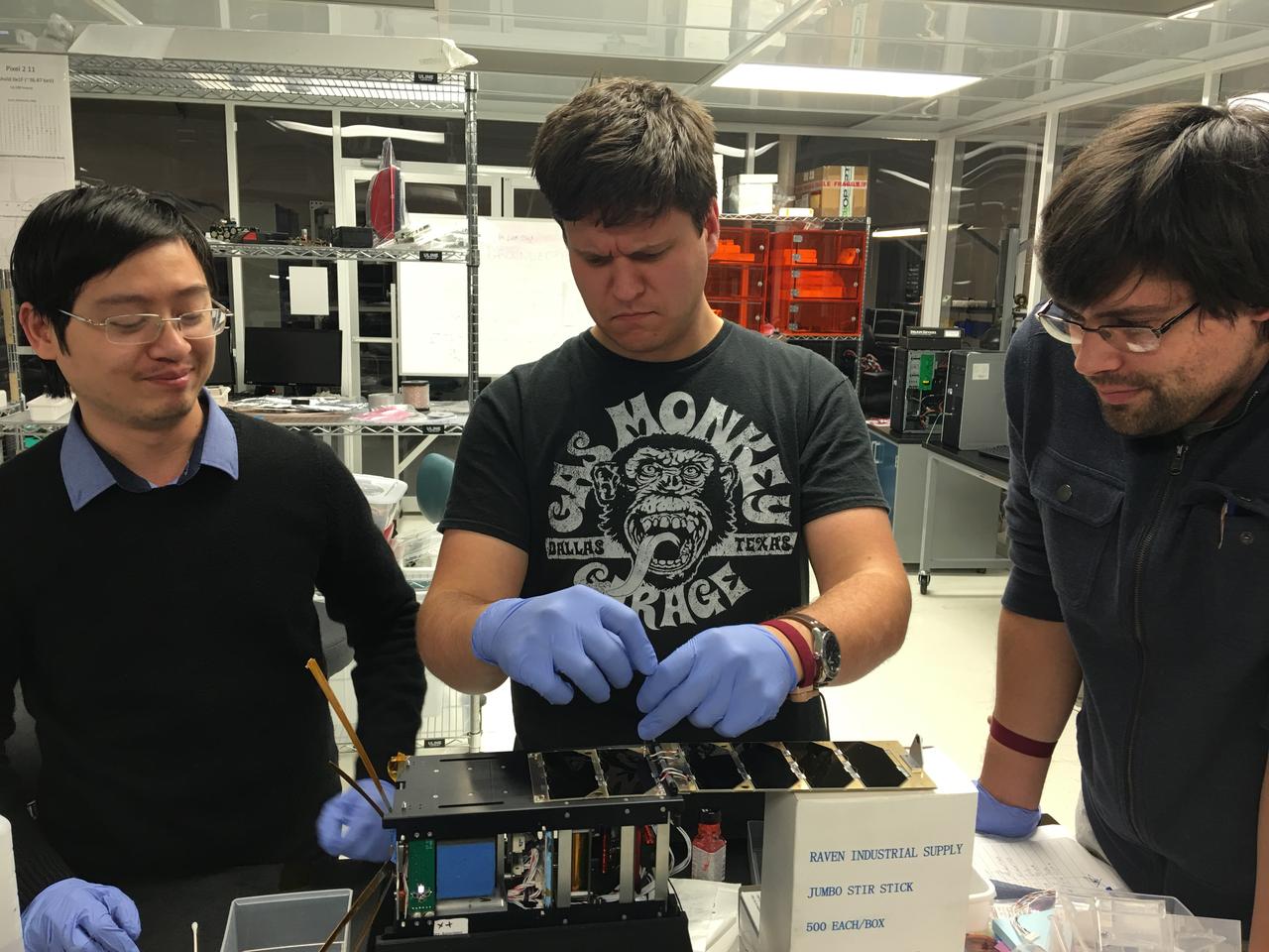 CXBN-2 Integration Team in the Morehead State University Spacecraft Integration and Assembly Facility.  Left to right:  Kein Dant, Yevgeniy Byleborodov, and Nate Richard.  The Cosmic X-Ray Background NanoSat-2 (CXBN-2) CubeSat Mission developed by Morehead State University and its partners the Keldysh Institute (Moscow, Russia), the Maysville Community and Technical College (Morehead, KY) and KYSpace LLC (Lexington, KY) will increase the precision of measurements of the Cosmic X-Ray Background in the 30-50 keV range to a precision of <5%, thereby constraining models that attempt to explain the relative contribution of proposed sources lending insight into the underlying physics of the early universe. The mission addresses a fundamental science question that is central to our understanding of the structure, origin, and evolution of the universe by potentially lending insight into both the high-energy background radiation and into the evolution of primordial galaxies. Launched by NASA’s CubeSat Launch Initiative NET April 18, 2017 ELaNa XVII mission on the seventh Orbital-ATK Cygnus Commercial Resupply Services (OA-7) to the International Space Station and deployed on tbd.
