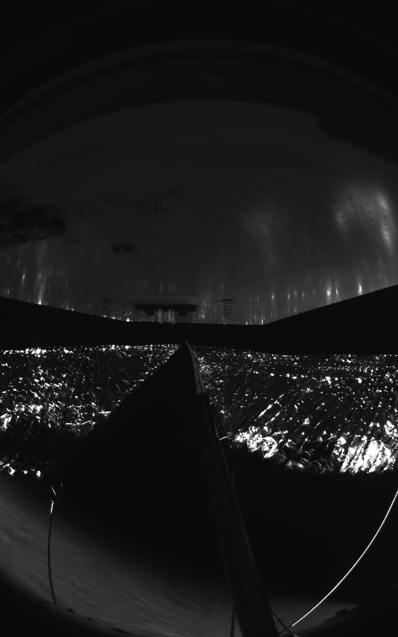 Four cameras aboard the Advanced Composite Solar Sail System spacecraft show the four reflective sail quadrants supported by composite booms. The booms are mounted at right angles and the spacecraft’s solar panel is rectangular, but lines appear distorted because of the wide-angle camera field of view.  View from a black-and-white wide-angle camera aboard the Advanced Composite Solar Sail System taken during sail unfurling in low Earth orbit. The spacecraft has four such cameras, centrally located aboard the spacecraft. Here, reflective sail quadrants supported by composite booms are seen when the booms are partially extended and the sail quadrants are not taut. At the top of the photo is the back surface of one of the spacecraft’s solar panels.  On the lower left Earth’s limb is seen below.