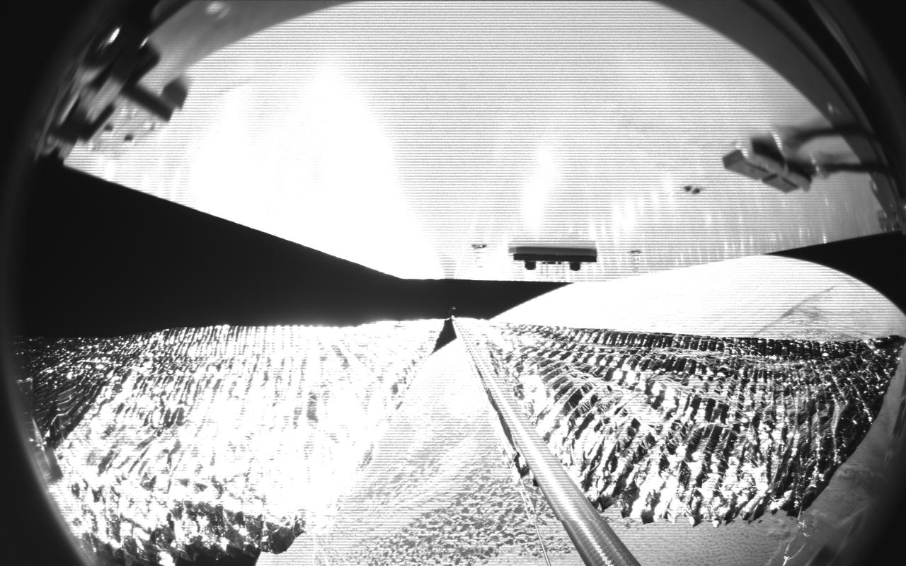Four cameras aboard the Advanced Composite Solar Sail System spacecraft show the four reflective sail quadrants supported by composite booms. The booms are mounted at right angles and the spacecraft’s solar panel is rectangular, but lines appear distorted because of the wide-angle camera field of view.  View from a black-and-white wide-angle camera aboard the Advanced Composite Solar Sail System taken during sail unfurling in low Earth orbit. The spacecraft has four such cameras, centrally located aboard the spacecraft. Here, reflective sail quadrants supported by composite booms are seen when the booms are partially extended and the sail quadrants are not taut. At the top of the photo is the back surface of one of the spacecraft’s solar panels.  On the lower right Earth is seen below.