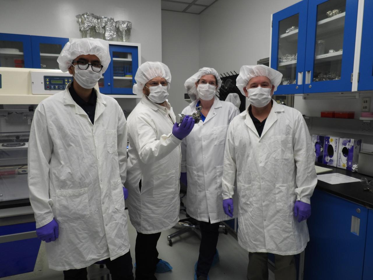 Researchers at NASA's Goddard Space Flight Center in Greenbelt, Maryland, pose with a cannister that contains a portion of the asteroid Bennu sample delivered to Earth by the agency's OSIRIS-REx (Origins, Spectral Interpretation, Resource Identification, and Security – Regolith Explorer) mission. From left to right: Angel Mojarro, organic geochemist; Jason Dworkin, OSIRIS-REX project scientist; Hannah McLain, astrobiologist; and Danny Glavin, senior sample scientist.