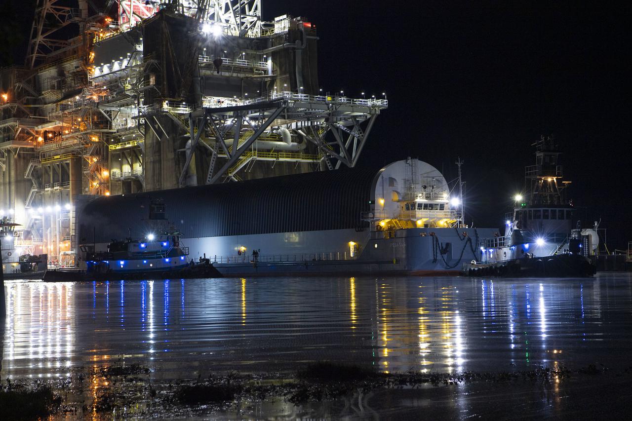 The first core stage of NASA’s Space Launch System (SLS) rocket, loaded onto the agency’s Pegasus barge, departs Stennis Space Center near Bay St. Louis, Mississippi, headed to Kennedy Space Center in Florida. The departure of the core stage in mid-April 2021 followed completion of a Green Run test series of the stage systems in preparation for its launch on the Artemis I mission. The Green Run series concluded with a March 18 hot fire of the stage’s four RS-25 engines on the B-2 Test Stand at Stennis, just as during an actual launch. Following refurbishment work, the stage was removed from the B-2 stand and loaded onto the Pegasus barge for transport. Once at Kennedy, the will be integrated with the rest of SLS rocket and prepared for the launch of the Artemis I mission to the Moon. Photo Credit: NASA