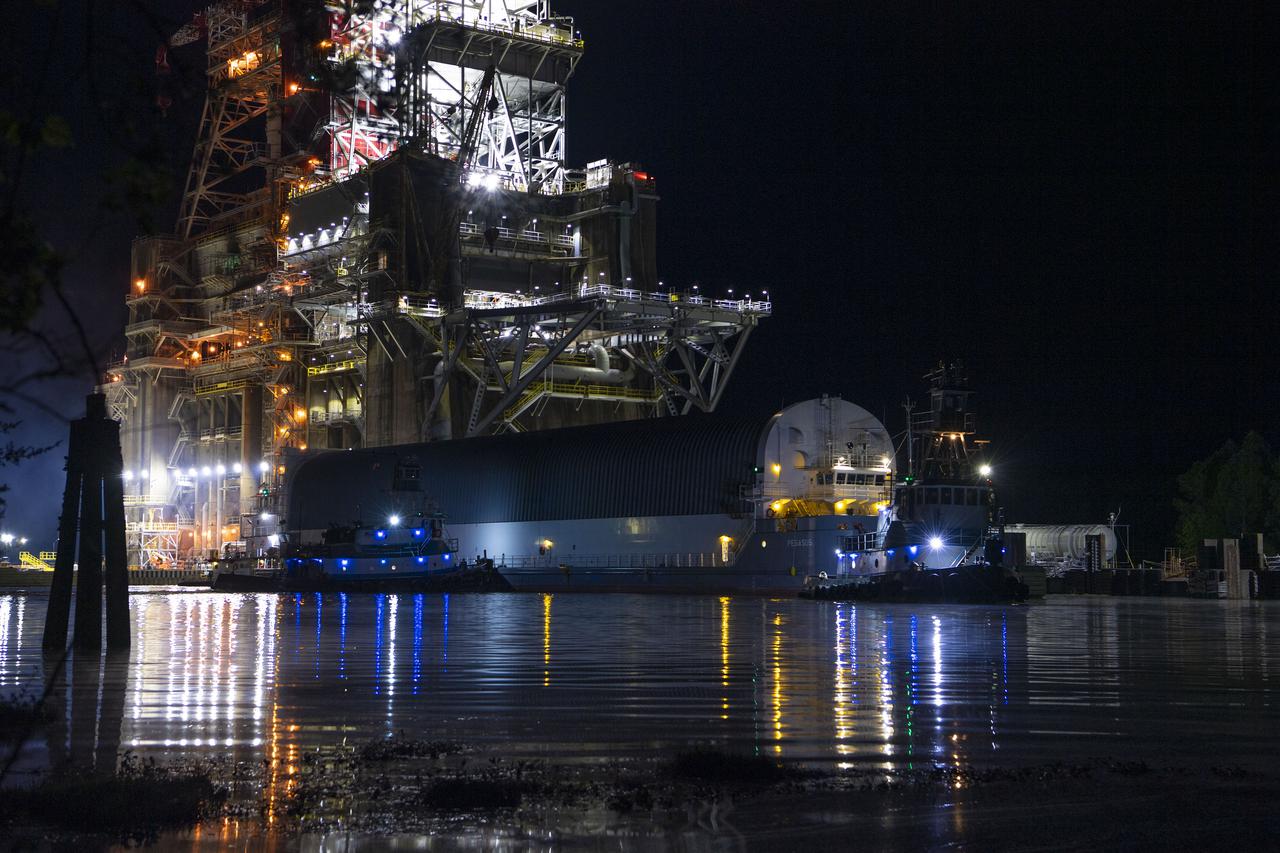 The first core stage of NASA’s Space Launch System (SLS) rocket, loaded onto the agency’s Pegasus barge, departs Stennis Space Center near Bay St. Louis, Mississippi, headed to Kennedy Space Center in Florida. The departure of the core stage in mid-April 2021 followed completion of a Green Run test series of the stage systems in preparation for its launch on the Artemis I mission. The Green Run series concluded with a March 18 hot fire of the stage’s four RS-25 engines on the B-2 Test Stand at Stennis, just as during an actual launch. Following refurbishment work, the stage was removed from the B-2 stand and loaded onto the Pegasus barge for transport. Once at Kennedy, the will be integrated with the rest of SLS rocket and prepared for the launch of the Artemis I mission to the Moon. Photo Credit: NASA
