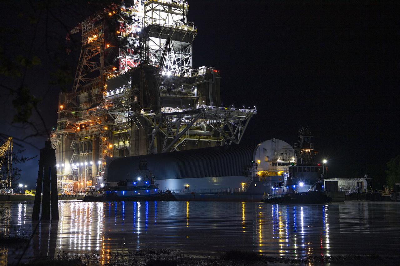 The first core stage of NASA’s Space Launch System (SLS) rocket, loaded onto the agency’s Pegasus barge, departs Stennis Space Center near Bay St. Louis, Mississippi, headed to Kennedy Space Center in Florida. The departure of the core stage in mid-April 2021 followed completion of a Green Run test series of the stage systems in preparation for its launch on the Artemis I mission. The Green Run series concluded with a March 18 hot fire of the stage’s four RS-25 engines on the B-2 Test Stand at Stennis, just as during an actual launch. Following refurbishment work, the stage was removed from the B-2 stand and loaded onto the Pegasus barge for transport. Once at Kennedy, the will be integrated with the rest of SLS rocket and prepared for the launch of the Artemis I mission to the Moon. Photo Credit: NASA