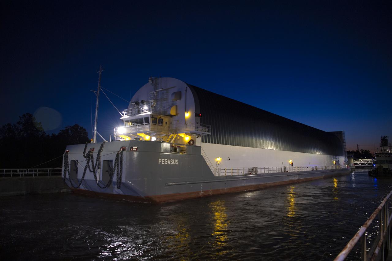 The first core stage of NASA’s Space Launch System (SLS) rocket, loaded onto the agency’s Pegasus barge, departs Stennis Space Center near Bay St. Louis, Mississippi, headed to Kennedy Space Center in Florida. The departure of the core stage in mid-April 2021 followed completion of a Green Run test series of the stage systems in preparation for its launch on the Artemis I mission. The Green Run series concluded with a March 18 hot fire of the stage’s four RS-25 engines on the B-2 Test Stand at Stennis, just as during an actual launch. Following refurbishment work, the stage was removed from the B-2 stand and loaded onto the Pegasus barge for transport. Once at Kennedy, the will be integrated with the rest of SLS rocket and prepared for the launch of the Artemis I mission to the Moon. Photo Credit: NASA