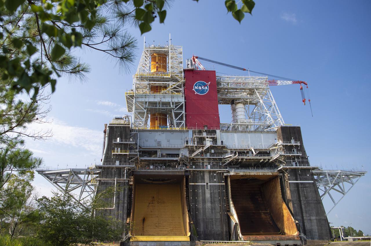A photo from the north (flame trench) side of the B-2 Test Stand at NASA’s Stennis Space Center shows the first flight core stage for NASA’s new Space Launch System (SLS) rocket installed for Green Run testing. The SLS core stage was transported to Stennis in January to begin Green Run testing prior to its use on the Artemis I mission. NASA is building SLS to return humans, including the first woman, to the Moon as part of the Artemis program and to prepare for eventual missions to Mars. At Stennis, the SLS core stage will undergo a series of tests on its integrated systems, culminating with a hot fire of its four RS-25 engines, just as during an actual launch.