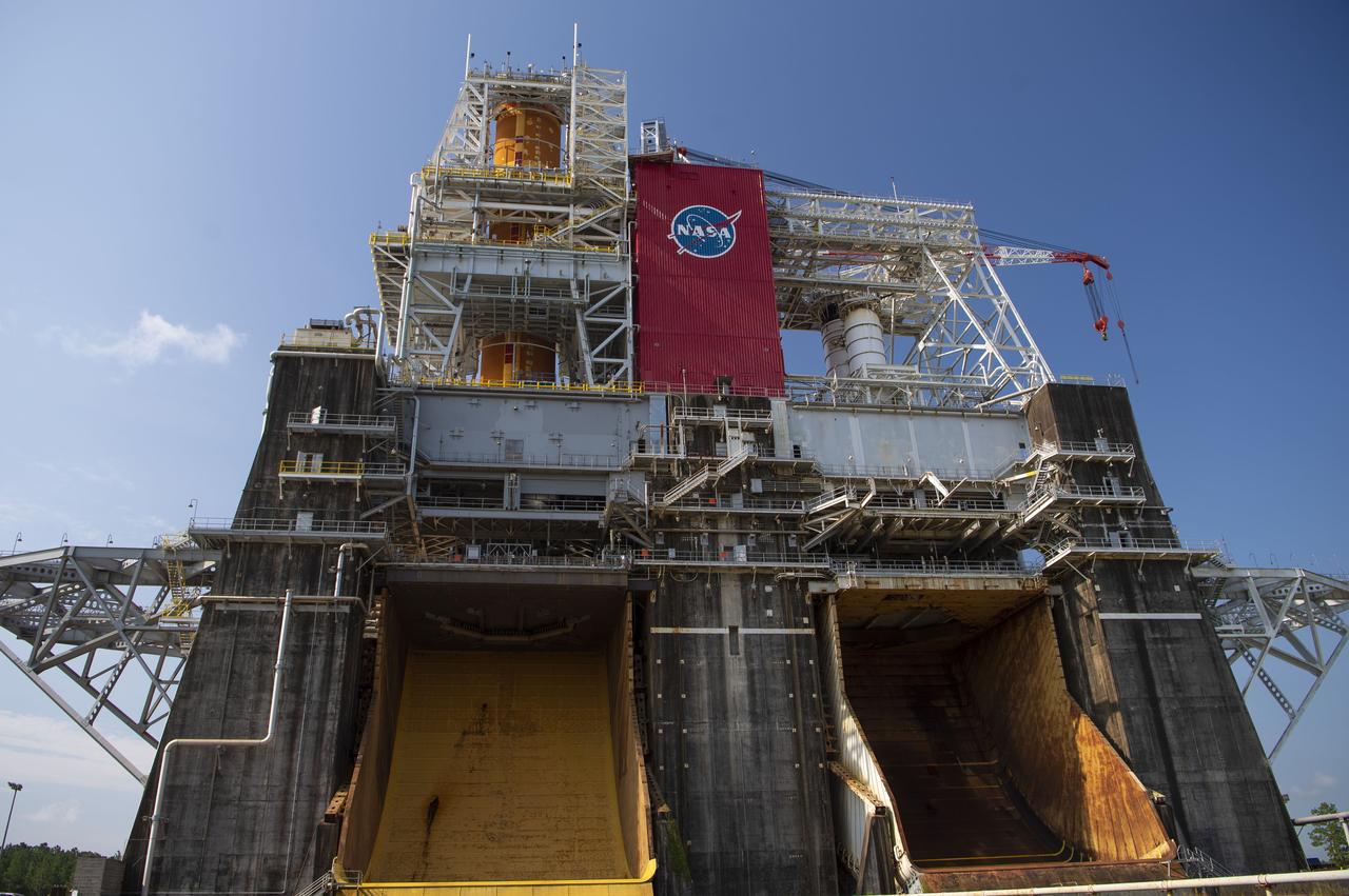 A photo from the north (flame trench) side of the B-2 Test Stand at NASA’s Stennis Space Center shows the first flight core stage for NASA’s new Space Launch System (SLS) rocket installed for Green Run testing. The SLS core stage was transported to Stennis in January to begin Green Run testing prior to its use on the Artemis I mission. NASA is building SLS to return humans, including the first woman, to the Moon as part of the Artemis program and to prepare for eventual missions to Mars. At Stennis, the SLS core stage will undergo a series of tests on its integrated systems, culminating with a hot fire of its four RS-25 engines, just as during an actual launch.