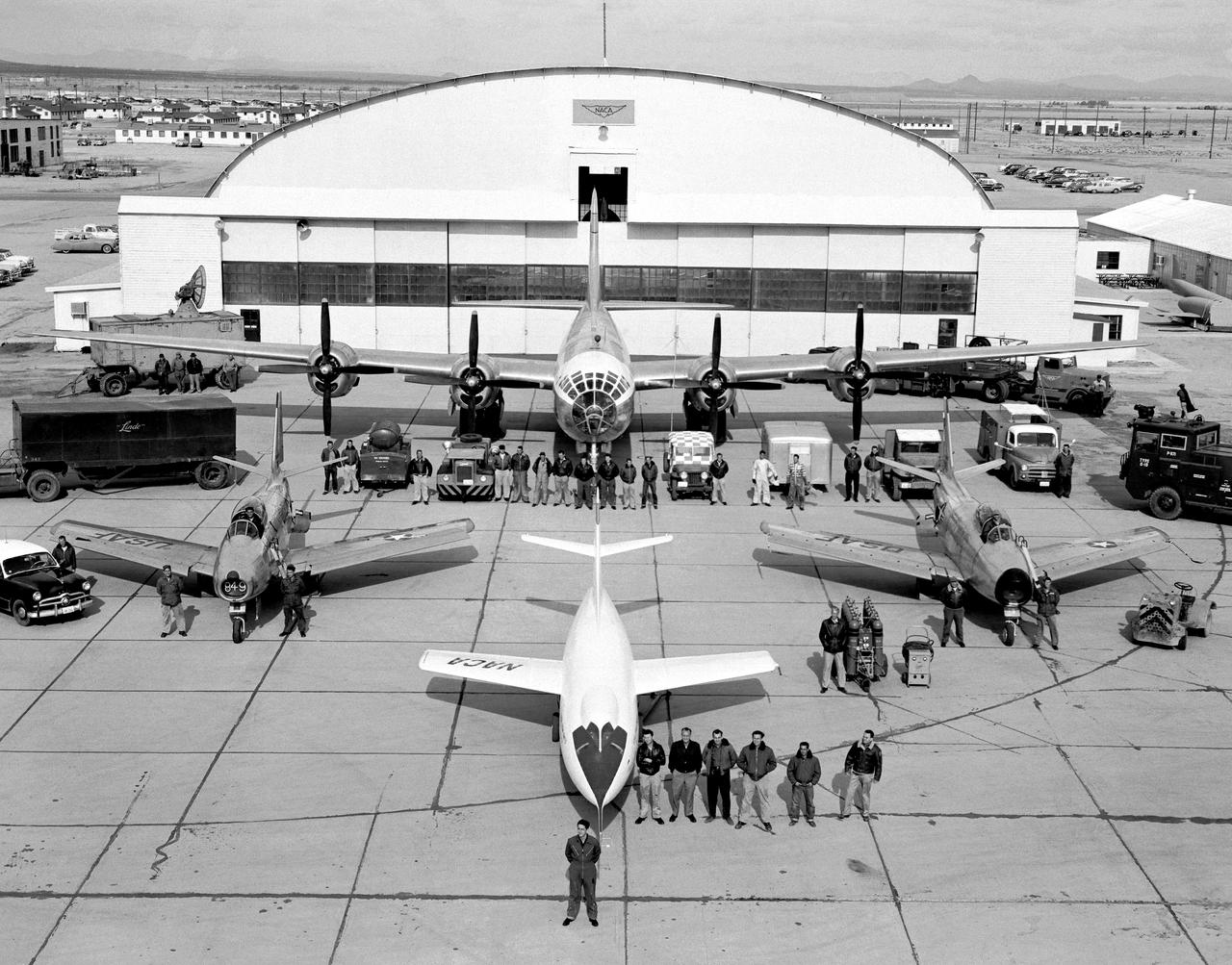 These people and this equipment supported the flight of the NACA D-558-2 Skyrocket at the High-Speed Flight Station at South Base, Edwards AFB. Note the two Sabre chase planes, the P2B-1S launch aircraft, and the profusion of ground support equipment, including communications, tracking, maintenance, and rescue vehicles. Research pilot A. Scott Crossfield stands in front of the Skyrocket.