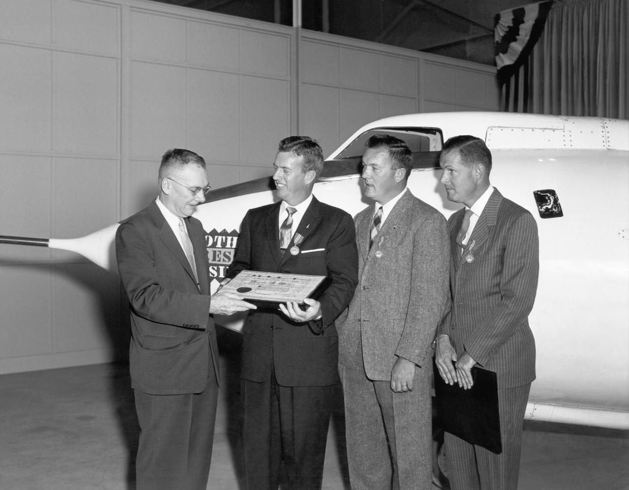 Hugh Dryden (far left) presents the NACA Exceptional Service Medal award at the NACA High Speed Flight Station. He awarded (L-R) Joe Walker (X-1A research pilot), Stan Butchart (pilot of the B-29 mothership),and Richard Payne (X-1A crew chief) in recognition of their research extending knowledge of swept wing flight.