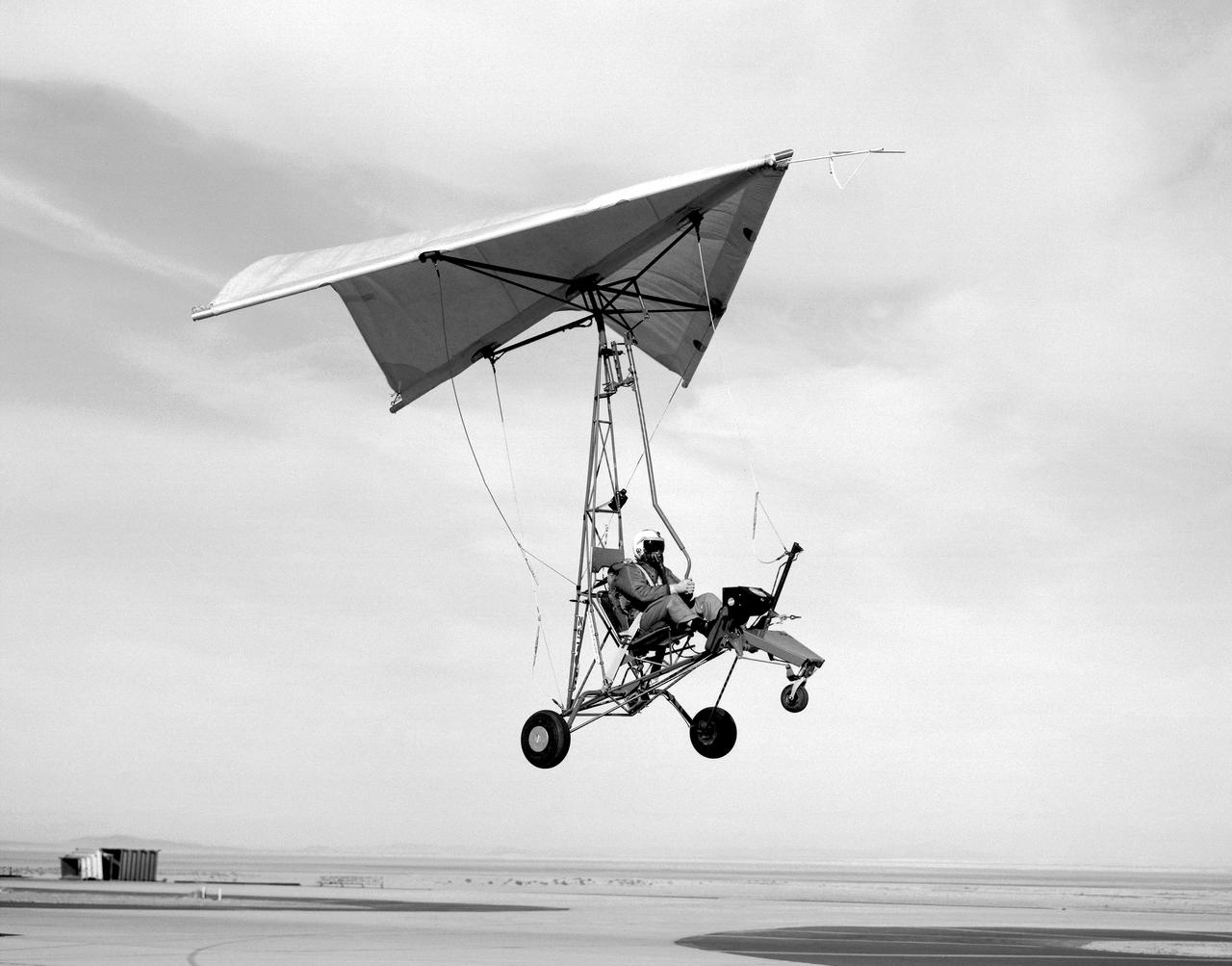Pilot and Paresev 1 preparing for a landing on the Rogers dry lakebed in 1962 at Edwards Air Force Base, California. The flight program began with ground tow tests. Several tows were made before liftoff was attempted to check the control rigging and to familiarize the pilot with the vehicle’s ground stability. As the pilot’s confidence and experience increased, tow speeds were also increased until liftoff was attained. Liftoff was at about 40 knots indicated airspeed (kias).