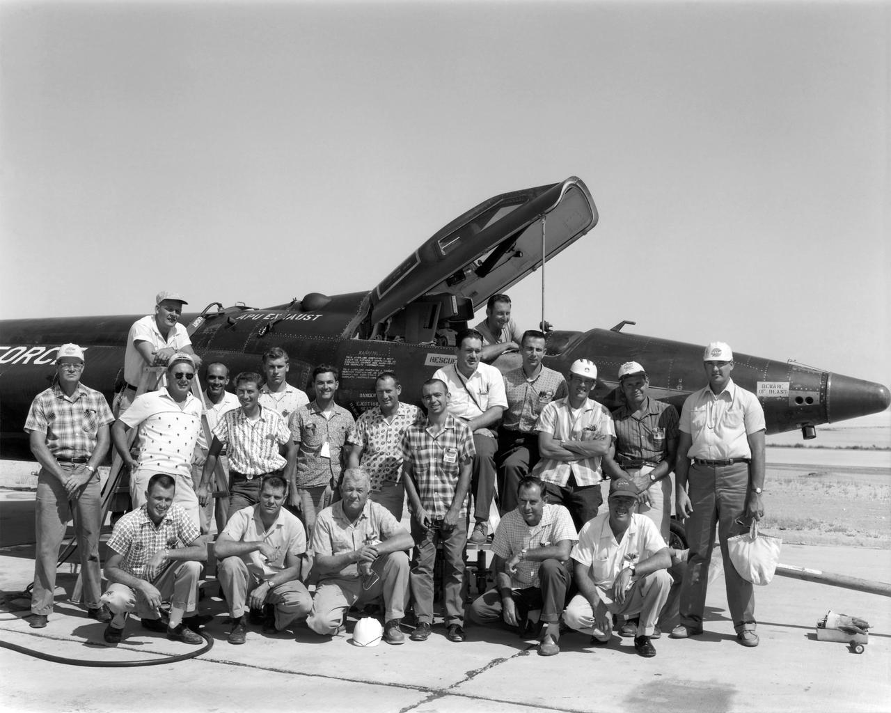 X-15 personnel July 1962 Cockpit: Edward "Ed" Nice Ladder: Thomas "Tom" McAlister  Back Row, left to right: William Clark, Edward "Ed" Sabo, Donald "Don" Hall, Billy Furr, Allen Dustin, Raymond "Ray" White, George E. Trott, Alfred "Al" Grieshaber, Merle Curtis, LeRoy "Lee" Adelsbach, Allen Lowe, Jay L. King, Lorenzo "Larry" Barnett.  Kneeling, left to right: Byron Gibbs, Price "Bob" Workman, Ira Cupp, unidentified, John Gordon.