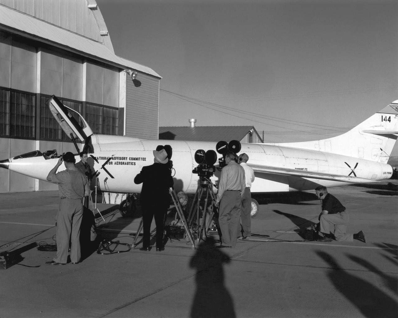 Scott Crossfield talks to newsmen in front of NACA South Base hangar after his first flight to Mach 2 in the Douglas D-558-2.
