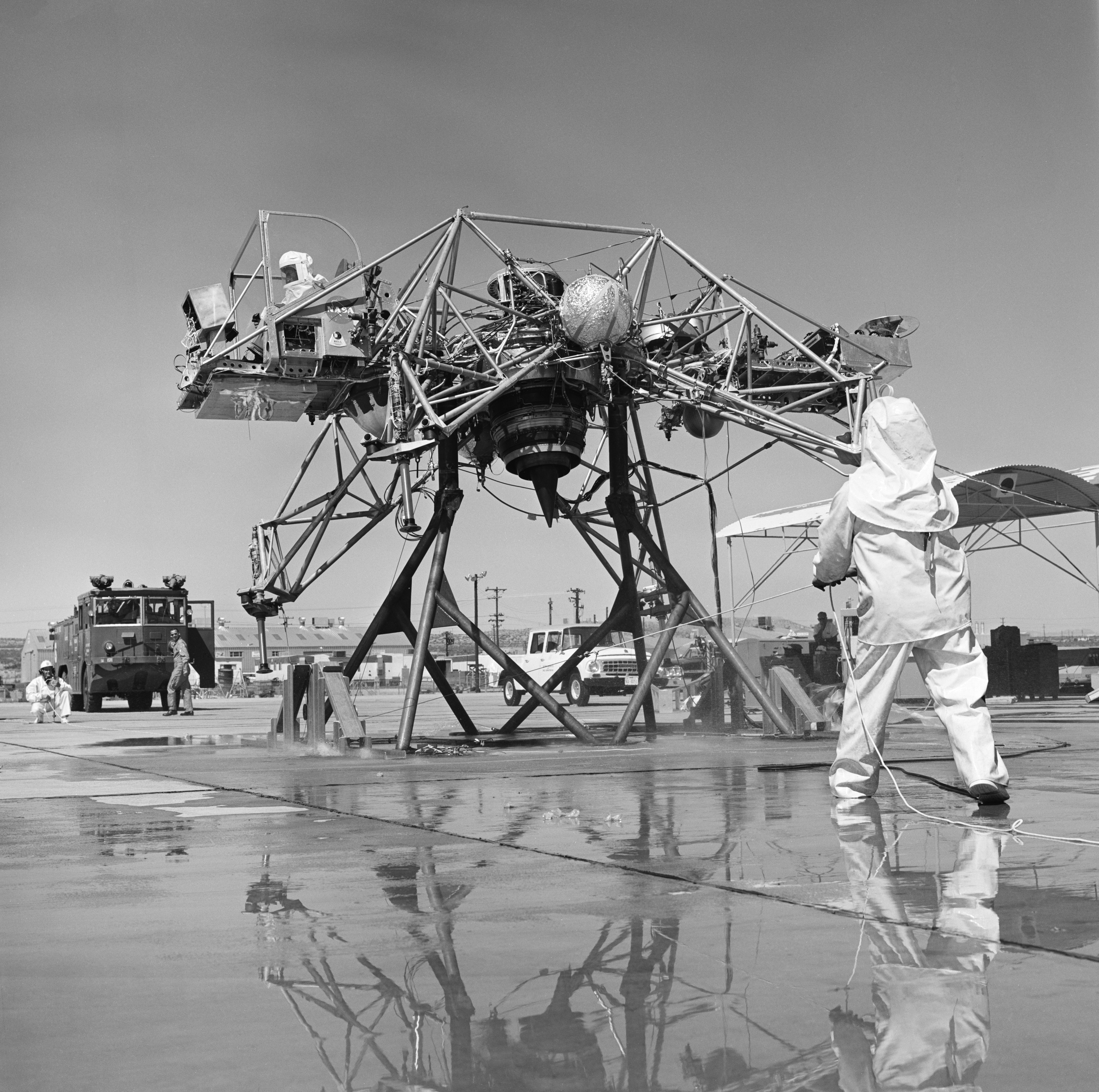Mechanics are dressed in fire suits because the Lunar Landing Research Vehicle, a simulator to train astronauts for a moon landing, had 90% pure hydrogen peroxide thrusters.