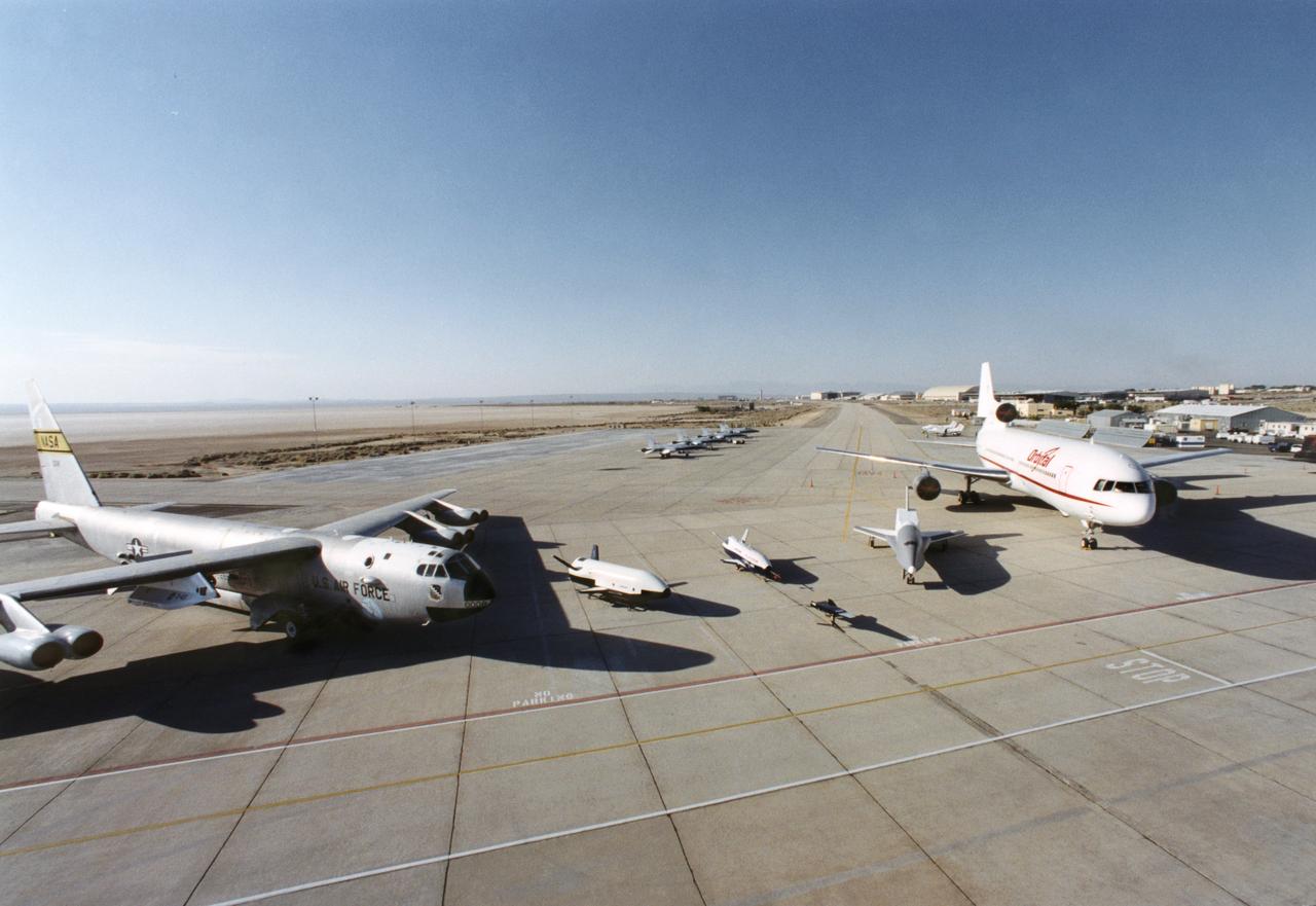 Aerospace industry representatives view actual and mock-up versions of 'X-Planes' intended to enhance access to space during a technical exposition on June 22, 2000 at Dryden Flight Research Center, Edwards, California. From left to right: NASA's B-52 launch aircraft, in service with NASA from 1959 to 2004; a neutral-buoyancy model of the Boeing's X-37; the Boeing X-40A behind the MicroCraft X-43 mock-up; Orbital Science's X-34 and the modified Lockheed L-1011 airliner that was intended to launch the X-34.  These X-vehicles are part of NASA's Access to Space plan intended to bring new technologies to bear in an effort to dramatically lower the cost of putting payloads in space, and near-space environments. The June 22, 2000 NASA Reusable Launch Vehicle (RLV) Technology Exposition included presentations on the history, present, and future of NASA's RLV program. Special Sessions for industry representatives highlighted the X-37 project and its related technologies. The X-37 project is managed by NASA's Marshall Space Flight Center, Huntsville, Alabama.