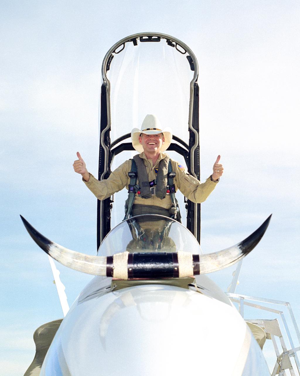 In a lighter mood, Ed Schneider gives a "thumbs-up" after his last flight at the Dryden Flight Research Center on September 19, 2000. Schneider arrived at the NASA Ames-Dryden Flight Research Facility on July 5, 1982, as a Navy Liaison Officer, becoming a NASA research pilot one year later. He has been project pilot for the F-18 High Angle-of-Attack program (HARV), the F-15 aeronautical research aircraft, the NASA B-52 launch aircraft, and the SR-71 "Blackbird" aircraft. He also participated in such programs as the F-8 Digital Fly-By-Wire, the FAA/NASA 720 Controlled Impact Demonstration, the F-14 Automatic Rudder Interconnect and Laminar Flow, and the F-104 Aeronautical Research and Microgravity projects.