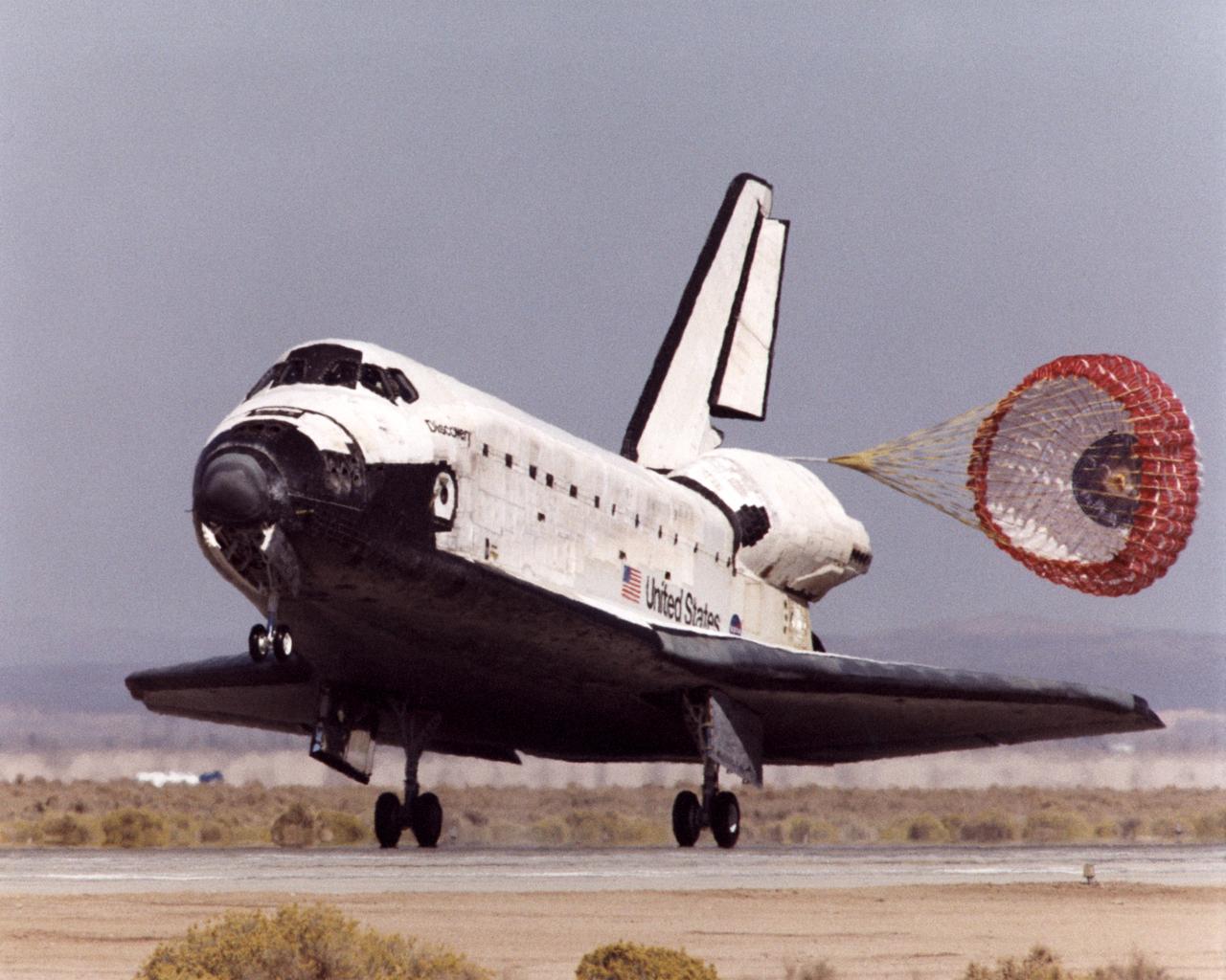 With its drag parachute deployed to help slow it down, the Space Shuttle Discovery rolls down the runway after landing at Edwards Air Force Base in Southern California at the conclusion of mission STS-92 on October 24, 2000.