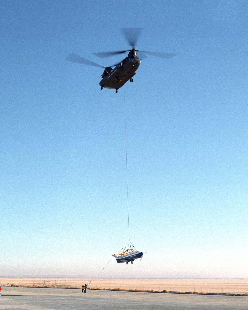 Ground crewmen help guide the alignment of the X-40 technology demonstrator as the experimental craft is gently lowered to the ground by a U.S. Army CH-47 Chinook cargo helicopter following a captive-carry test flight at NASA's Dryden Flight Research Center, Edwards, California. The X-40 is an unpowered 82 percent scale version of the X-37, a Boeing-developed spaceplane designed to demonstrate various advanced technologies for development of future lower-cost access to space vehicles. The X-37 will be carried into space aboard a space shuttle and then released to perform various maneuvers and a controlled re-entry through the Earth's atmosphere to an airplane-style landing on a runway, controlled entirely by pre-programmed computer software. Following a series of captive-carry flights, the X-40 made several free flights from a launch altitude of about 15,000 feet above ground, gliding to a fully autonomous landing. The captive carry flights helped verify the X-40's navigation and control systems, rigging angles for its sling, and stability and control of the helicopter while carrying the X-40 on a tether.