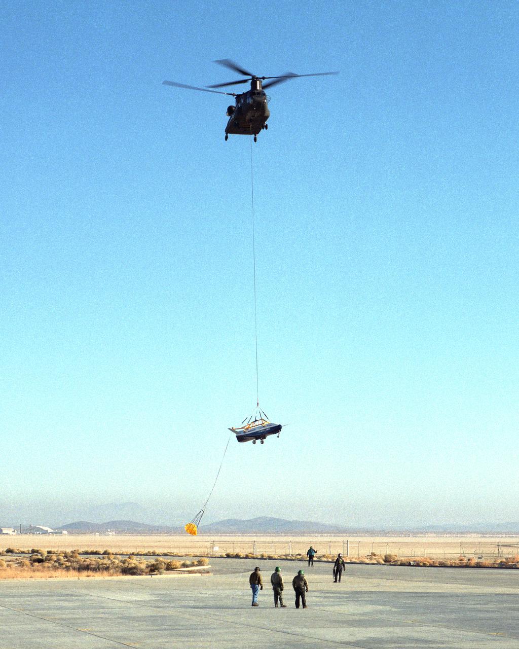 A U.S. Army CH-47 Chinook helicopter slowly lowers the X-40 sub-scale technology demonstrator to the ground under the watchful eyes of ground crew at the conclusion of a captive-carry test flight at NASA's Dryden Flight Research Center, Edwards, California. Several captive-carry flights were conducted to check out all operating systems and procedures before the X-40 made its first free flight at Edwards, gliding to a fully-autonomous approach and landing on the Edwards runway. The X-40 is an unpowered 82 percent scale version of the X-37, a Boeing-developed spaceplane designed to demonstrate various advanced technologies for development of future lower-cost access to space vehicles. Flight tests of the X-40 are designed to reduce the risks associated with research flights of the larger, more complex X-37.