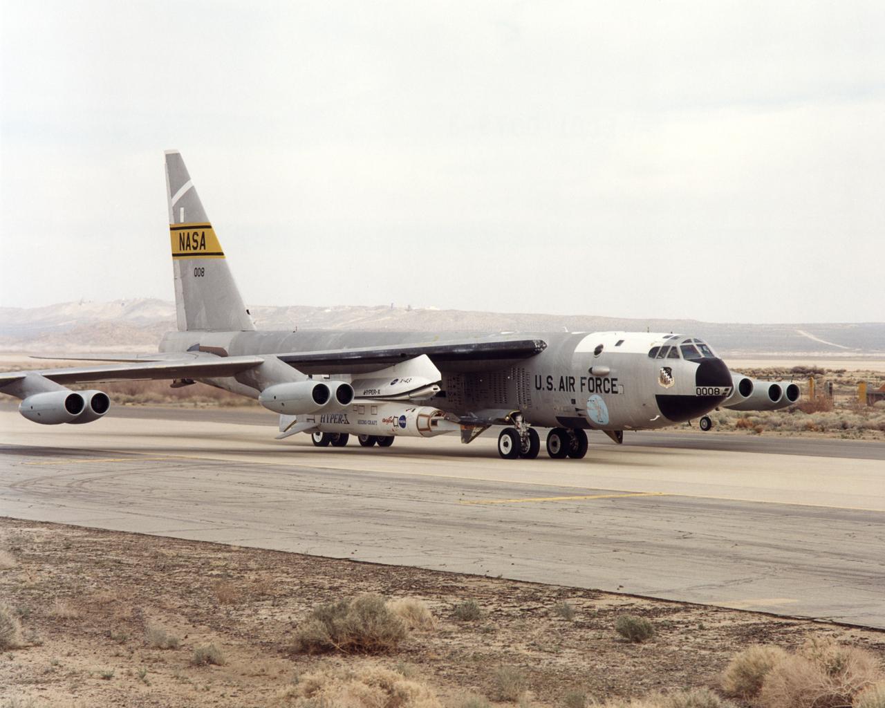 NASA's NB-52B carrier aircraft rolls down a taxiway at Edwards Air Force Base with the X-43A hypersonic research aircraft and its modified Pegasus® booster rocket slung from a pylon under its right wing. Part of a combined systems test conducted by NASA's Dryden Flight Research Center at Edwards, the taxi test was one of the last major milestones in the Hyper-X research program before the first X-43A flight. The X-43A flights will be the first actual flight tests of an aircraft powered by a revolutionary supersonic-combustion ramjet ("scramjet") engine capable of operating at hypersonic speeds (above Mach 5, or five times the speed of sound). The 12-foot, unpiloted research vehicle was developed and built by MicroCraft Inc., Tullahoma, Tenn., under NASA contract. The booster was built by Orbital Sciences Corp., Dulles, Va.,After being air-launched from NASA's venerable NB-52 mothership, the booster will accelerate the X-43A to test speed and altitude. The X-43A will then separate from the rocket and fly a pre-programmed trajectory, conducting aerodynamic and propulsion experiments until it descends into the Pacific Ocean. Three research flights are planned, two at Mach 7 and one at Mach 10, with the first tentatively scheduled for late spring to early summer, 2001.