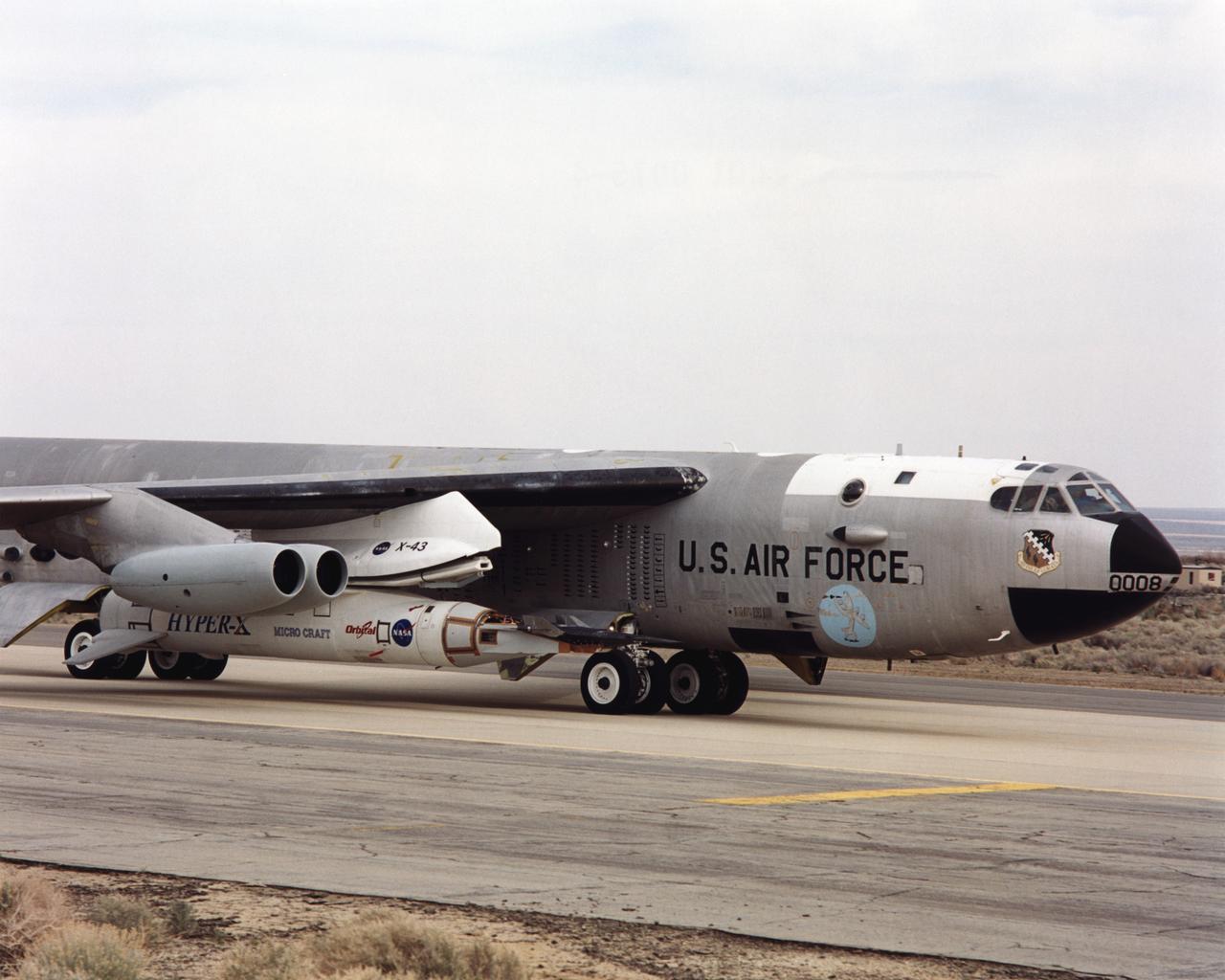 As part of a combined systems test conducted by NASA Dryden Flight Research Center, NASA's NB-52B carrier aircraft rolls down a taxiway at Edwards Air Force Base with the X-43A hypersonic research aircraft and its modified Pegasus® booster rocket attached to a pylon under its right wing. The taxi test was one of the last major milestones in the Hyper-X research program before the first X-43A flight. The X-43A flights will be the first actual flight tests of an aircraft powered by a revolutionary supersonic-combustion ramjet ("scramjet") engine capable of operating at hypersonic speeds (above Mach 5, or five times the speed of sound). The 12-foot, unpiloted research vehicle was developed and built by MicroCraft Inc., Tullahoma, Tenn., under NASA contract. The booster was built by Orbital Sciences Corp., Dulles, Va. After being air-launched from NASA's venerable NB-52 mothership, the booster will accelerate the X-43A to test speed and altitude. The X-43A will then separate from the rocket and fly a pre-programmed trajectory, conducting aerodynamic and propulsion experiments until it descends into the Pacific Ocean. Three research flights are planned, two at Mach 7 and one at Mach 10.