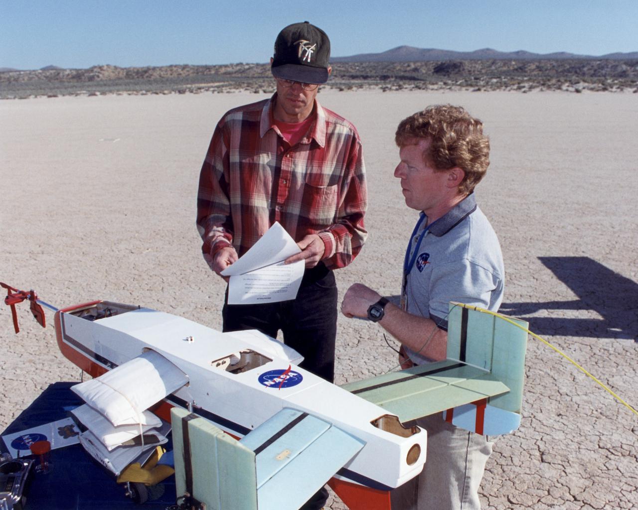 Engineers Jim Murray and Joe Pahle prepare a deployable, inflatable wing technology demonstrator experiment flown by the NASA Dryden Flight Research Center, Edwards, California. The inflatable wing project represented a basic flight research effort by Dryden personnel. Three successful flights of the I2000 inflatable wing aircraft occurred. During the flights, the team air-launched the radio-controlled (R/C) I2000 from an R/C utility airplane at an altitude of 800-1000 feet.  As the I2000 separated from the carrier aircraft, its inflatable wings "popped-out," deploying rapidly via an on-board nitrogen bottle. The aircraft remained stable as it transitioned from wingless to winged flight. The unpowered I2000 glided down to a smooth landing under complete control.