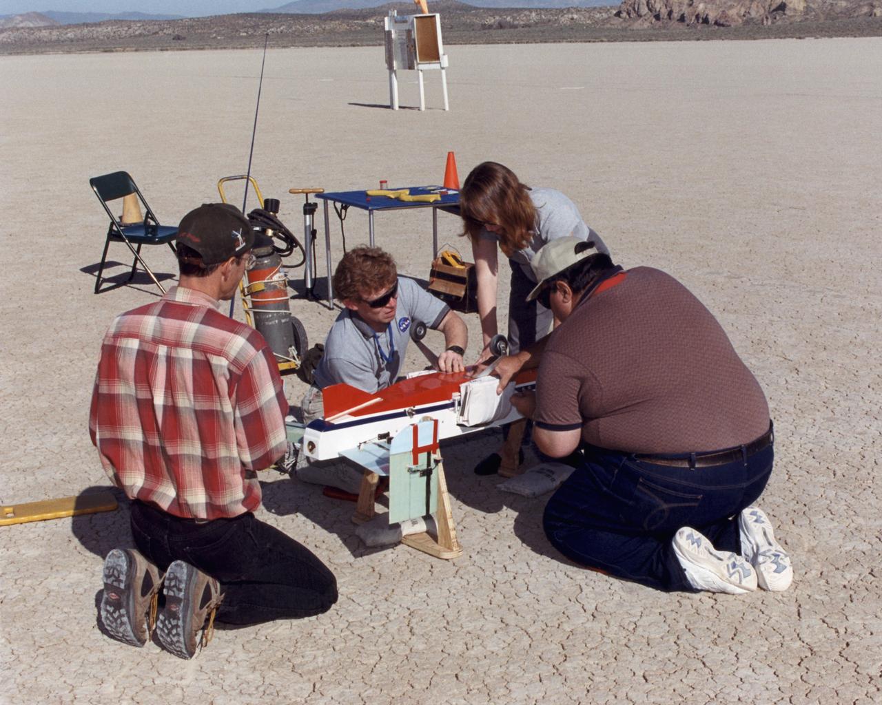 Inflatable Wing project personnel prepare a deployable, inflatable wing technology demonstrator experiment flown by the NASA Dryden Flight Research Center, Edwards, California. The inflatable wing project represented a basic flight research effort by Dryden personnel. Three successful flights of the I2000 inflatable wing aircraft occurred. During the flights, the team air-launched the radio-controlled (R/C) I2000 from an R/C utility airplane at an altitude of 800-1000 feet.  As the I2000 separated from the carrier aircraft, its inflatable wings "popped-out," deploying rapidly via an on-board nitrogen bottle. The aircraft remained stable as it transitioned from wingless to winged flight. The unpowered I2000 glided down to a smooth landing under complete control.