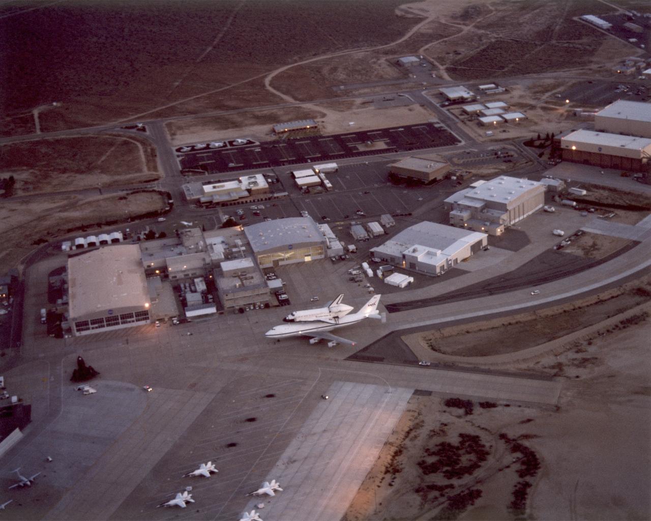 Aerial photo of NASA Dryden Flight Research Center with the Endeavour Space Shuttle and 747 Shuttle Carrier Aircraft taxiing on ramp.