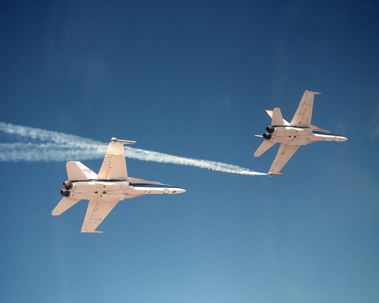 Smoke generators show the twisting paths of wingtip vortices behind two NASA Dryden F/A-18 jets used in the Autonomous Formation Flight (AFF) program
