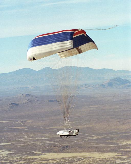 NASA image: The X-38 prototype of the Crew Return Vehicle is suspended under its giant 7,500-square-foot parafoil during its eighth free flight on Thursday, December 13, 2001