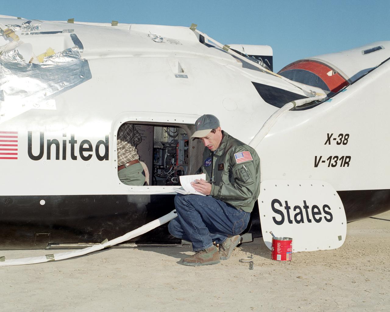 NASA engineer Wayne Peterson from the Johnson Space Center reviews postflight checklists following a spectacular flight of the X-38 prototype for a crew recovery vehicle that may be built for the International Space Station. The X-38 tested atmospheric flight characteristics on December 13, 2001, in a descent from 45,000 feet to Rogers Dry Lake at the NASA Dryden Flight Research Center/Edwards Air Force Base complex in California.