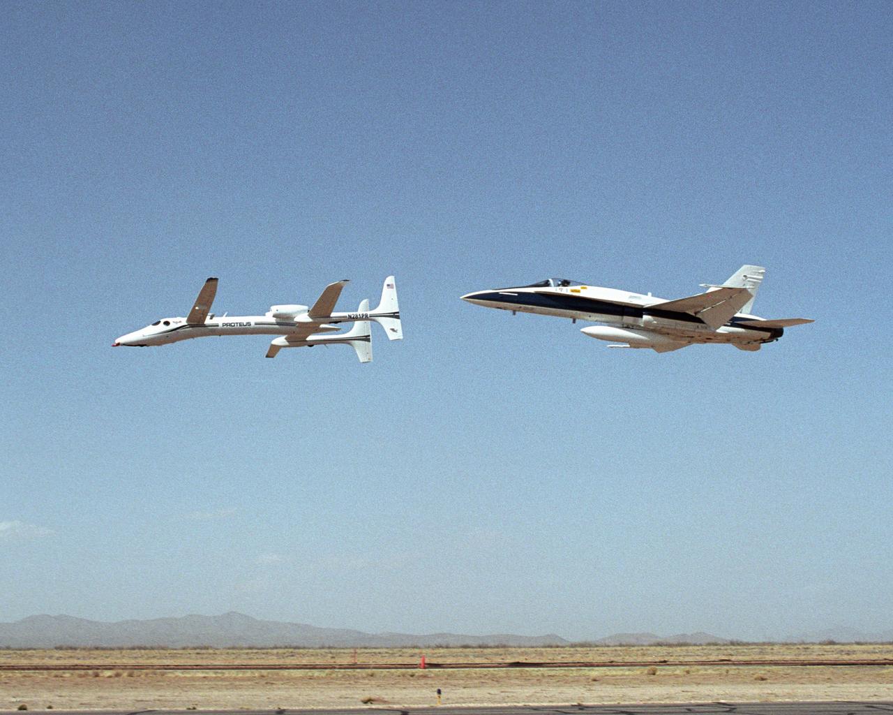 Scaled Composites' Proteus aircraft and an F/A-18 Hornet from NASA's Dryden Flight Research Center during a low-level flyby at Las Cruces Airport in New Mexico.