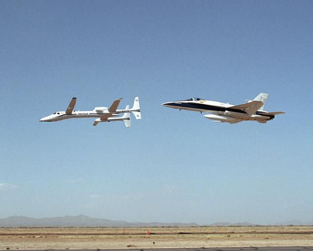 NASA image: Scaled Composites' Proteus aircraft and an F/A-18 Hornet from NASA's Dryden Flight Research Center during a low-level flyby at Las Cruces Airport in New Mexico.