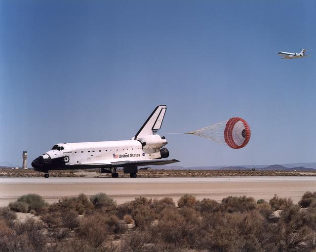 The Space Shuttle Endeavour's drag chute deploys to slow the orbiter as it rolls out on Runway 22 at Edwards Air Force Base at the conclusion of its 14-day STS-111 mission to the International Space Station