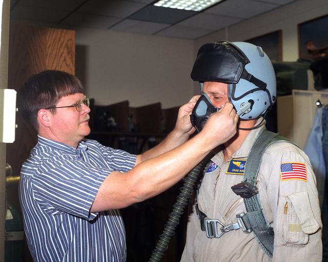 NASA image: Jeff Greulich, DynCorp life support technician, adjusts a prototype helmet on a NASA Dryden pilot. Five pilots evaluated the helmet for fit, comfort and functionality during the summer and fall of 2002.