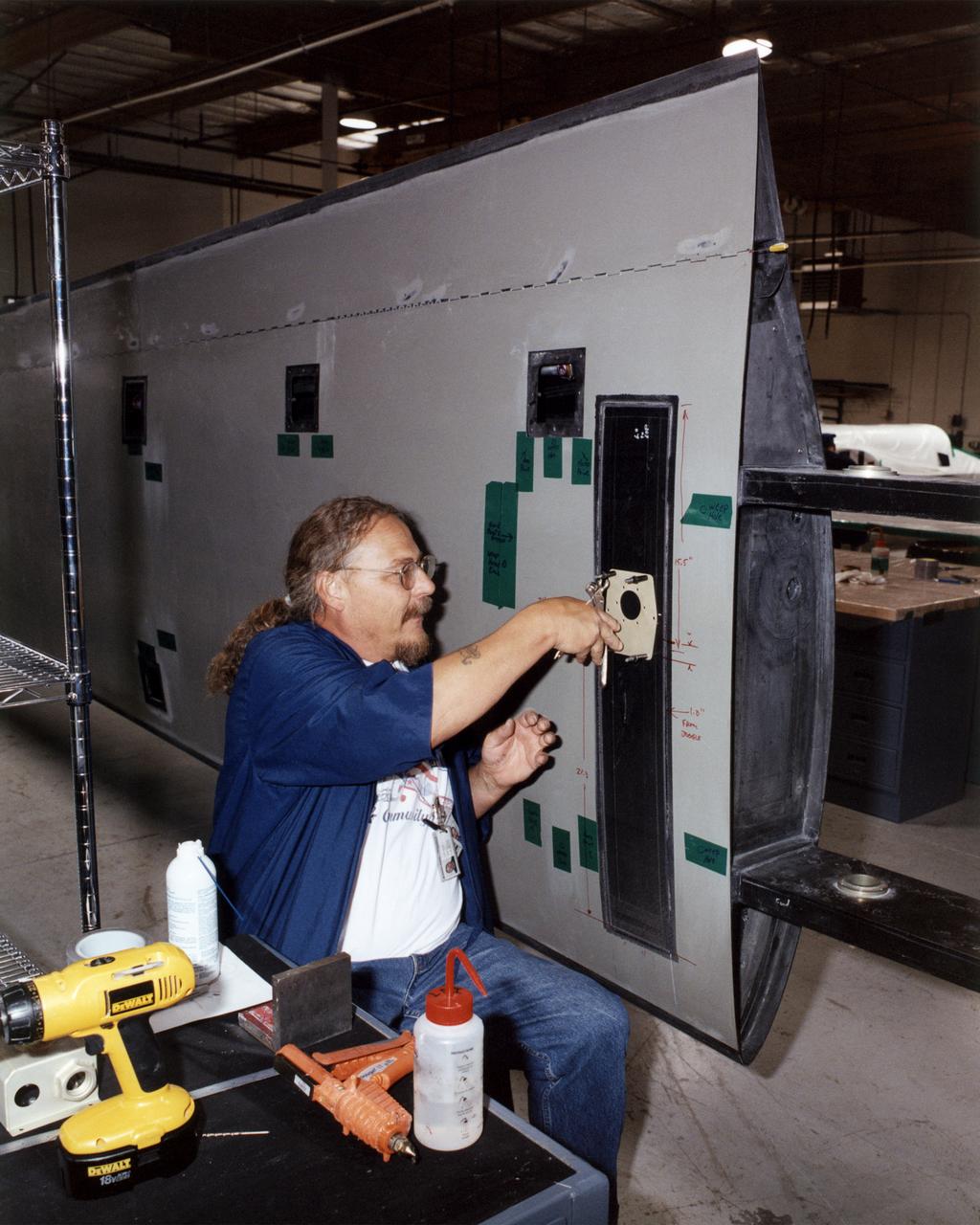 Technician Dave Brown installs a drilling template during construction of the all-composite left wing of NASA's Altair aircraft at General Atomics Aeronautical Systems, Inc., (GA-ASI) facility at Adelanto, Calif.