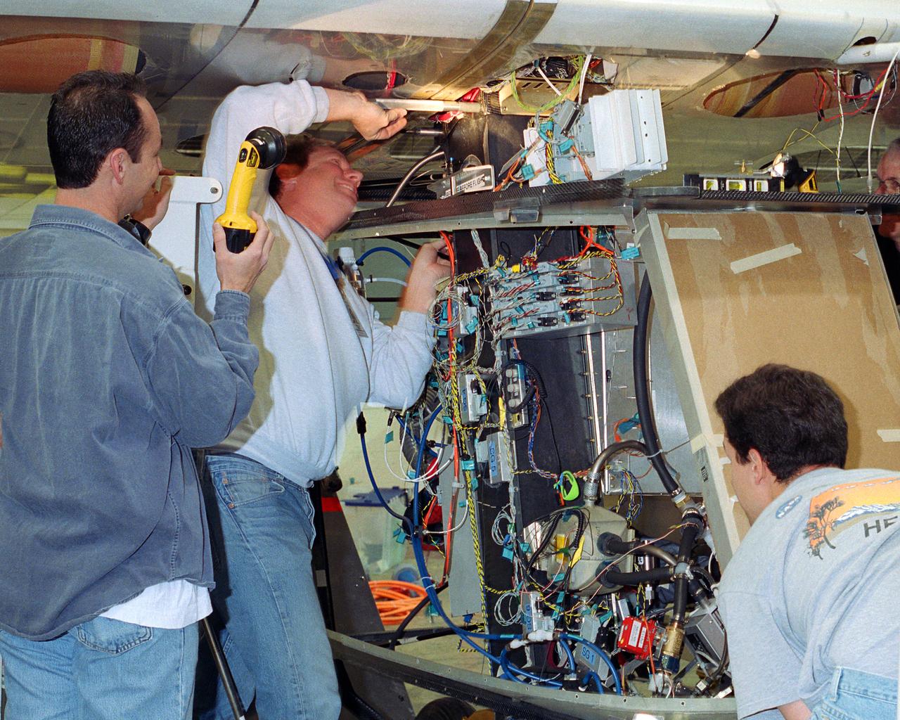 Aerovironment technicians carefully line up attachments as a fuel cell electrical system is installed on the Helios Prototype solar powered flying wing. The fuel cell system will power the aircraft at night during NASA-sponsored long-endurance demonstration flight in the summer of 2003.
