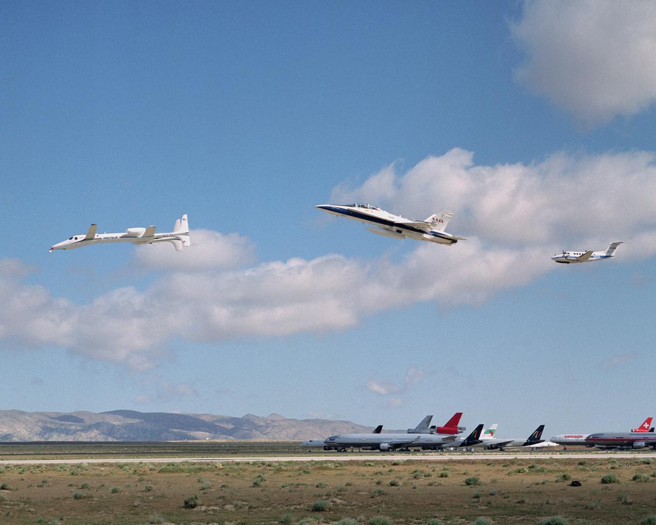 Scaled Composites' Proteus aircraft with an F/A-18 Hornet and a Beechcraft KingAir from NASA's Dryden Flight Research Center during a low-level flyby at Mojave Airport in Southern California.  The unique tandem-wing Proteus was the testbed for a series of UAV collision-avoidance flight demonstrations. An Amphitech 35GHz radar unit installed below Proteus' nose was the primary sensor for the Detect, See and Avoid tests.
