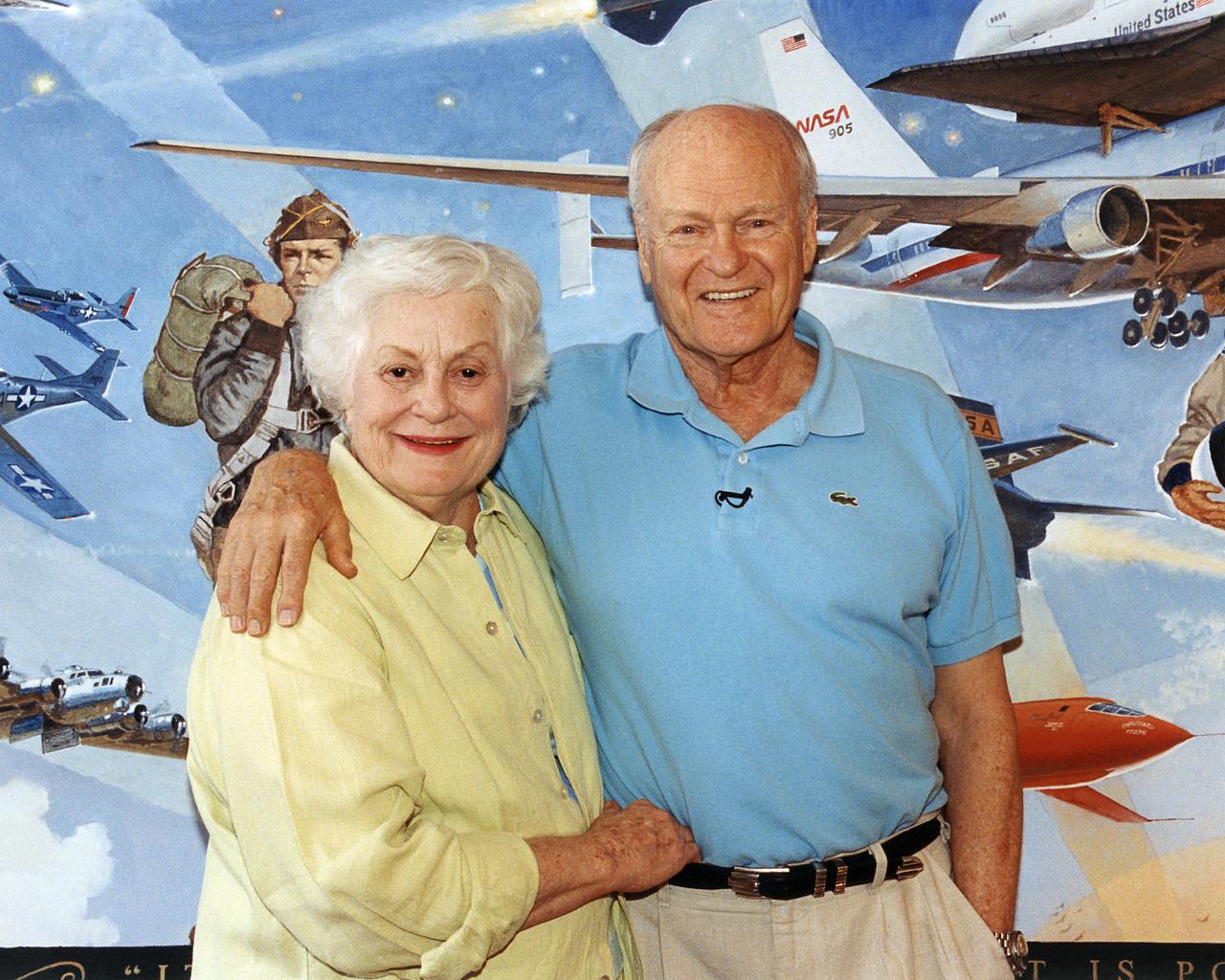 Artists Bob and Louise McCall in their Paradise Valley, Arizona studio, in front of "Celebrating One Hundred Years of Powered Flight 1903-2003." The mural was created to celebrate the achievements of Wilbur and Orville Wright and to commemorate a century of powered flight. Many of the epic flights represented in the painting took place in the skies over NASA Dryden Flight Research Center. An equally important goal of this celebration is to encourage the values that have characterized 100 years of aviation history: ingenuity, inventiveness, persistence, creativity and courage. These values hold true not just for pioneers of flight, but also for all pioneers of invention and innovation, and they will remain an important part of America's future.  "Celebrating One Hundred Years of Powered Flight, 1903-2003", documents many significant achievements in aeronautics and space flight from the dawn of powered flight to the present.  Historic aircraft and spacecraft serve as the backdrop, highlighting six figures representing the human element that made these milestones possible. These figures stand, symbolically supported by the words of Wilbur Wright, "It is my belief that flight is possible…" The quote was taken from a letter written to his father on September 3rd, 1900, announcing Wilbur's intention to make "some experiments with a flying machine" at Kitty Hawk, North Carolina.  "This year, Bob is helping us commemorate the Centennial of Flight with a beautiful mural slated for placement in our Dryden Flight Research Center that documents the history of flight from the Wright Flyer to the International Space Station. We should all take note, I think, that in the grand scheme of things, one hundred years is a very short period of time. In that blink of an eye we've gone from Kitty Hawk to Tranquility Base and now look forward to our rovers traversing the surface of Mars. Despite the challenges we face, the future we envision, like the future depicted in the artwork of Bo