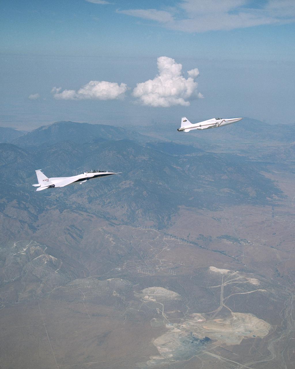 NASA's F-15B research testbed jet from NASA's Dryden Flight Research Center flew in the supersonic shockwave of a Northrop Grumman Corp. modified U.S. Navy F-5E jet in support of the Shaped Sonic Boom Demonstration (SSBD) project, which is part of the DARPA's Quiet Supersonic Platform (QSP) program.  The project is an effort to lessen sonic booms.  During the recent demonstration, the F-15B flew behind the modified F-5E sonic boom demonstrator aircraft in order to measure the aircraft's sonic boom characteristics.  Flying behind and below the F-5E, and using its specially-instrumented nose boom, the F-15B recorded many shockwave patterns from the F-5E at various distances and orientations from the aircraft.