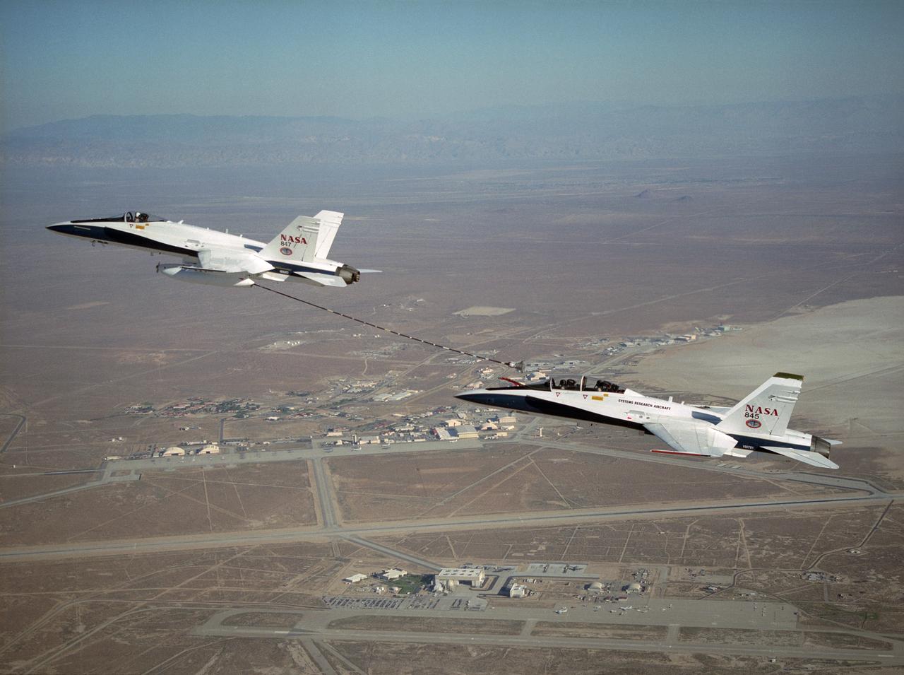 NASA Dryden's Automated Aerial Refueling (AAR) project evaluated the capability of an F/A-18A aircraft as an in-flight refueling tanker with the objective of developing analytical models for an automated aerial refueling system for unmanned air vehicles. The F/A-18 "tanker" aircraft (No. 847) underwent flight test envelope expansion with an aerodynamic pod containing air-refueling equipment carried beneath the fuselage. The second aircraft flew as the receiver aircraft during the study to assess the free-stream hose and drogue dynamics on the F/A-18A.